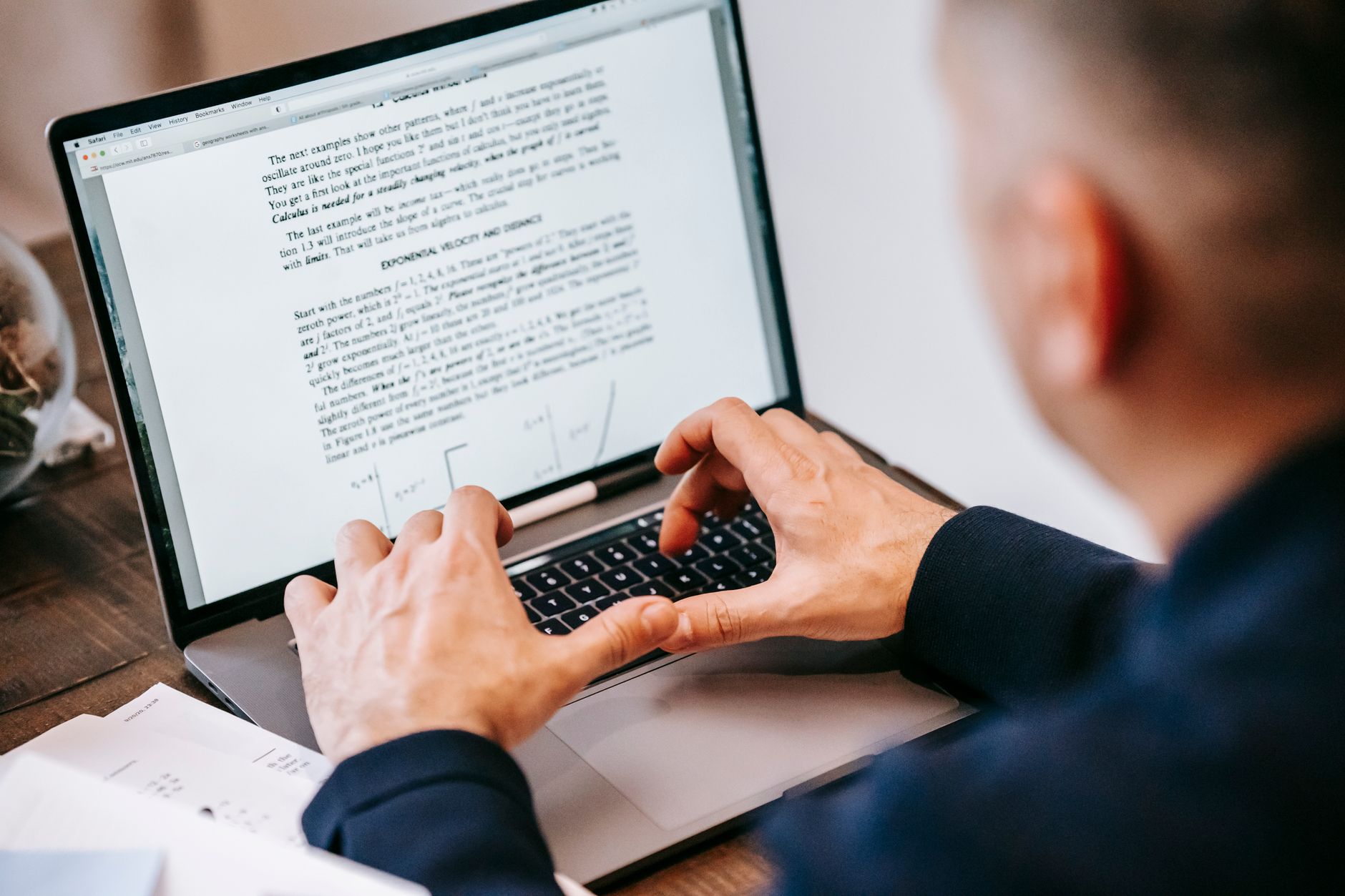 Mężczyzna piszący na laptopie w domowym biurze, skupiony na pracy.